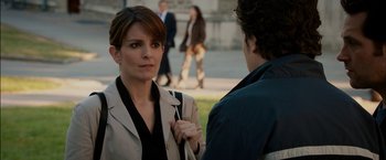 Movie still from “Admission” (2013), directed by Paul Weitz – A woman in a beige jacket is talking to a man in a brown jacket; Medium shot, Over the shoulder angle