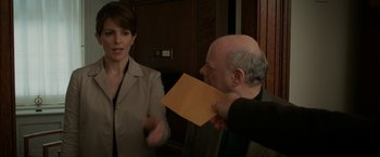 Movie still from “Admission” (2013), directed by Paul Weitz – An older man holding an envelope while an older woman looks on; Medium shot, Over the shoulder angle