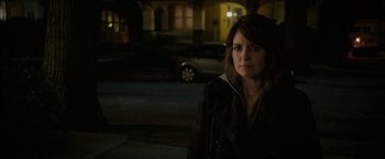 Movie still from “Admission” (2013), directed by Paul Weitz – A woman standing on the side of the street at night; Close Up shot, Over the shoulder angle