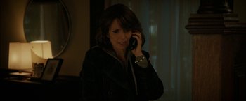 Movie still from “Admission” (2013), directed by Paul Weitz – A woman talking on a cell phone while standing in a room; Close Up shot, Over the shoulder angle