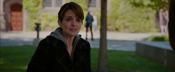 Movie still from “Admission” (2013), directed by Paul Weitz – A person outside near a tree; Close Up shot, Over the shoulder angle