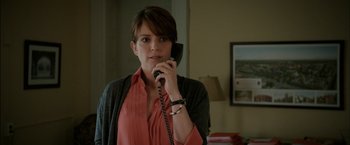 Movie still from “Admission” (2013), directed by Paul Weitz – A woman talking on a phone while wearing a red shirt; Close Up shot, Over the shoulder angle