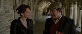 Movie still from “Admission” (2013), directed by Paul Weitz – A man and a woman are standing in a hallway; Medium shot, Over the shoulder angle