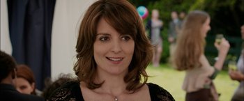 Movie still from “Admission” (2013), directed by Paul Weitz – A person smiling for the camera; Close Up shot, Over the shoulder angle