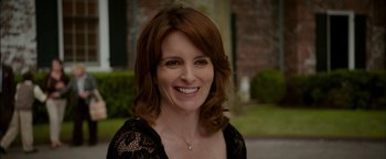 Movie still from “Admission” (2013), directed by Paul Weitz – A person smiling for a picture; Close Up shot, Over the shoulder angle