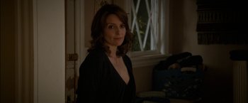 Movie still from “Admission” (2013), directed by Paul Weitz – A woman in a black shirt standing in front of a window; Close Up shot, Over the shoulder angle