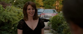 Movie still from “Admission” (2013), directed by Paul Weitz – A woman standing in front of a red car; Close Up shot, Over the shoulder angle