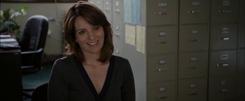 Movie still from “Admission” (2013), directed by Paul Weitz – A woman standing in front of some filing cabinets; Close Up shot, Over the shoulder angle