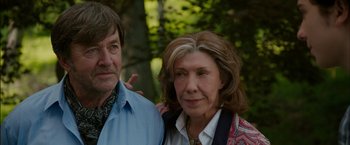 Movie still from “Admission” (2013), directed by Paul Weitz – A man standing next to an older woman in front of trees; Close Up shot, Over the shoulder angle