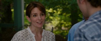Movie still from “Admission” (2013), directed by Paul Weitz – A person smiling with trees in the background; Close Up shot, Over the shoulder angle