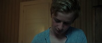 Movie still from “Adoration” (2019), directed by Fabrice du Welz – A young man with short blonde hair looking down at his face; Close Up shot, Over the shoulder angle