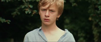 Movie still from “Adoration” (2019), directed by Fabrice du Welz – A young man with blonde hair is looking at the camera; Close Up shot, Low angle