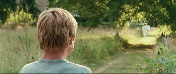Movie still from “Adoration” (2019), directed by Fabrice du Welz – A young man is looking out at a field; Close Up shot, Over the shoulder angle