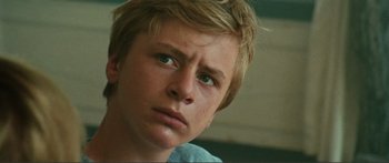 Movie still from “Adoration” (2019), directed by Fabrice du Welz – A person with short blonde hair; Close Up shot, Low angle