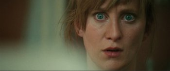 Movie still from “Adoration” (2019), directed by Fabrice du Welz – A woman's blue eyes and red hair; Extreme Close Up shot, Low angle
