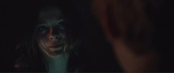 Movie still from “Adoration” (2019), directed by Fabrice du Welz – A woman's face in the dark; Close Up shot, Over the shoulder angle