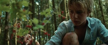 Movie still from “Adoration” (2019), directed by Fabrice du Welz – A woman in a forest with berries on the ground; Close Up shot, Low angle