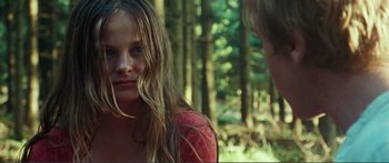 Movie still from “Adoration” (2019), directed by Fabrice du Welz – A young girl with long blonde hair is talking to a young man; Close Up shot, Over the shoulder angle