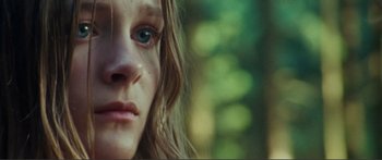 Movie still from “Adoration” (2019), directed by Fabrice du Welz – A woman's face in a forest; Extreme Close Up shot, Low angle