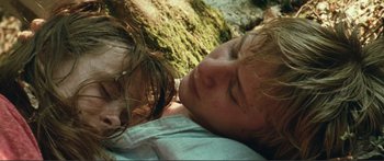 Movie still from “Adoration” (2019), directed by Fabrice du Welz – A man and a woman laying on the ground next to each other; Close Up shot, Overhead angle