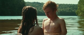 Movie still from “Adoration” (2019), directed by Fabrice du Welz – A man and a woman in a body of water; Medium shot, Over the shoulder angle