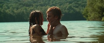 Movie still from “Adoration” (2019), directed by Fabrice du Welz – A man and a woman in a body of water; Medium shot, High angle