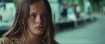 Movie still from “Adoration” (2019), directed by Fabrice du Welz – A young girl with long hair looking into the distance; Close Up shot, Over the shoulder angle
