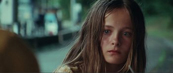 Movie still from “Adoration” (2019), directed by Fabrice du Welz – A person with long brown hair; Close Up shot, High angle