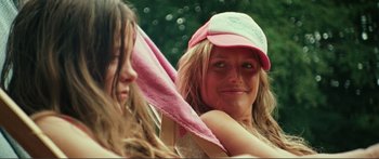 Movie still from “Adoration” (2019), directed by Fabrice du Welz – A woman in a pink hat holding a pink towel; Close Up shot, Low angle
