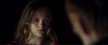Movie still from “Adoration” (2019), directed by Fabrice du Welz – A young girl with long blonde hair stares into the camera; Close Up shot, Over the shoulder angle