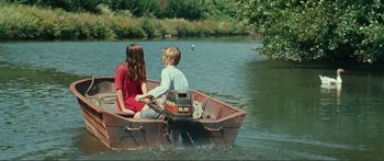 Movie still from “Adoration” (2019), directed by Fabrice du Welz – Two people in a boat on a river; Wide shot, High angle