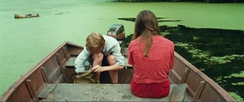 Movie still from “Adoration” (2019), directed by Fabrice du Welz – A man and a woman sitting on a boat; Wide shot, High angle