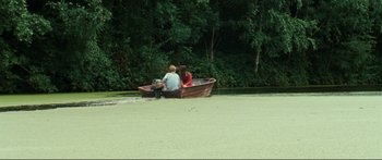 Movie still from “Adoration” (2019), directed by Fabrice du Welz – Two people are sitting in a boat on the water; Extreme Wide shot, High angle