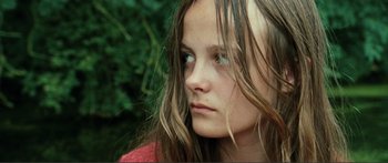 Movie still from “Adoration” (2019), directed by Fabrice du Welz – A young girl with long brown hair and green eyes; Close Up shot, High angle