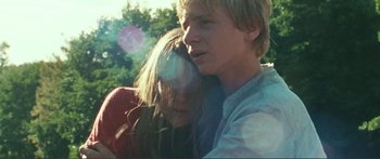 Movie still from “Adoration” (2019), directed by Fabrice du Welz – A man and a woman hugging each other outside; Close Up shot, Low angle