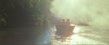 Movie still from “Adoration” (2019), directed by Fabrice du Welz – Two people in a boat on a river; Extreme Wide shot, High angle