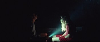 Movie still from “Adoration” (2019), directed by Fabrice du Welz – A man and a woman sitting in the dark; Medium shot, Over the shoulder angle