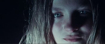 Movie still from “Adoration” (2019), directed by Fabrice du Welz – A girl's face with blue eyes; Extreme Close Up shot, Low angle