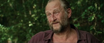 Movie still from “Adoration” (2019), directed by Fabrice du Welz – An old man with a beard and a mustache; Close Up shot, Over the shoulder angle