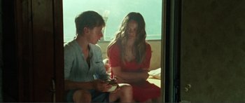 Movie still from “Adoration” (2019), directed by Fabrice du Welz – A man and a woman sitting next to each other; Medium shot, Over the shoulder angle