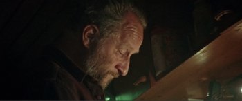 Movie still from “Adoration” (2019), directed by Fabrice du Welz – An older man with a beard looking down; Close Up shot, Low angle