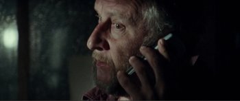 Movie still from “Adoration” (2019), directed by Fabrice du Welz – An older man talking on a cell phone; Close Up shot, Low angle