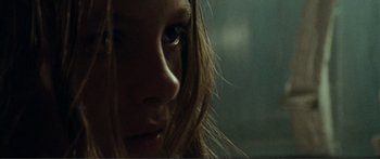 Movie still from “Adoration” (2019), directed by Fabrice du Welz – A woman's face in a dark room; Extreme Close Up shot, Low angle