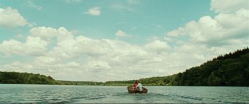 Movie still from “Adoration” (2019), directed by Fabrice du Welz – Two people are sitting in a boat on the water; Extreme Wide shot, High angle