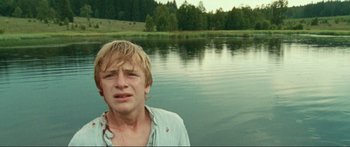 Movie still from “Adoration” (2019), directed by Fabrice du Welz – A man crying in front of a body of water; Close Up shot, Low angle