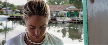 Movie still from “Adrift” (2018), directed by Baltasar Kormákur – A person wearing a necklace near a body of water; Close Up shot, High angle