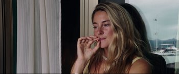 Movie still from “Adrift” (2018), directed by Baltasar Kormákur – A beautiful young lady taking a bite out of a piece of food; Close Up shot, High angle