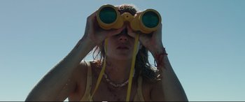 Movie still from “Adrift” (2018), directed by Baltasar Kormákur – A woman looking through a pair of binoculars; Close Up shot, Low angle