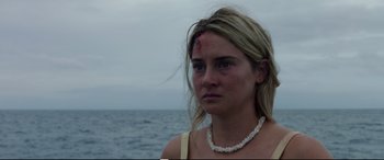 Movie still from “Adrift” (2018), directed by Baltasar Kormákur – A young woman with a bruised face standing in front of a body of water; Close Up shot, Over the shoulder angle