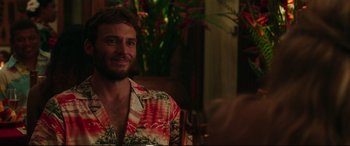 Movie still from “Adrift” (2018), directed by Baltasar Kormákur – A man wearing a hawaiian shirt sitting at a table; Medium shot, Over the shoulder angle